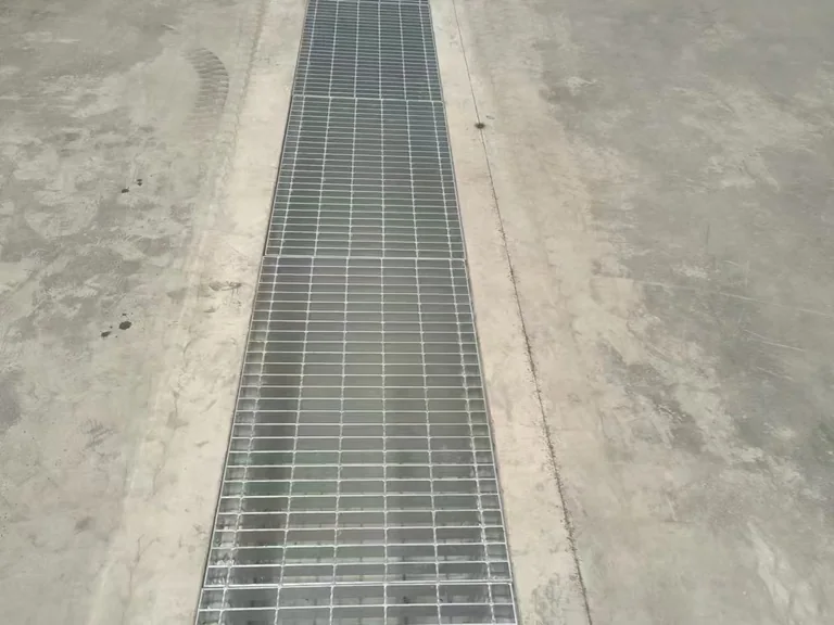 Indoor steel grating drain cover over floor trench